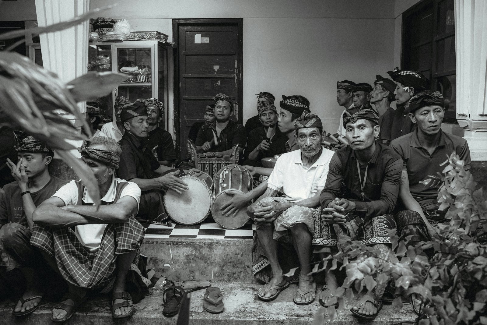 A black and white photograph of a diverse group of people, including Indigenous Australian community members and healthcare workers, seated together in an indoor community space engaged in what appears to be a health discussion or educational meeting.