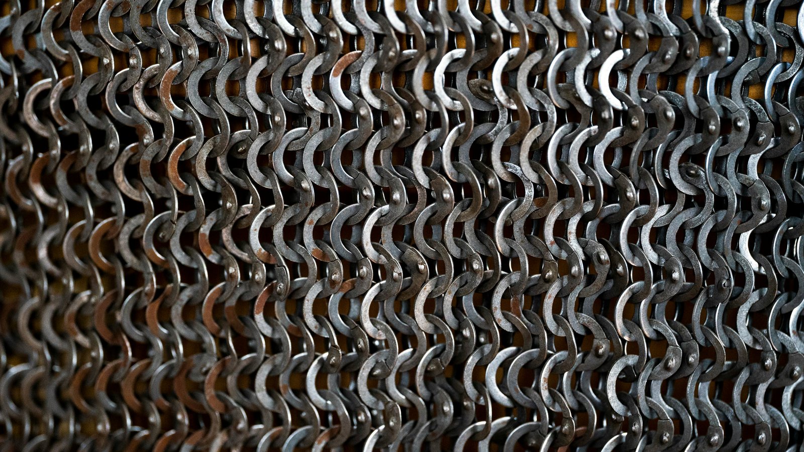 Close-up view of metallic heat exchanger tubes with densely packed spiral fins creating a repetitive wave pattern across the frame.